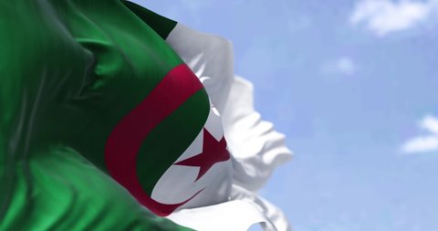 Detail of the national flag of Algeria waving in the wind on a clear day. Patriotism. Selective focus. Seamless Slow motion