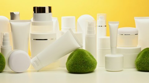 jar, bottle and empty white plastic tubes for cosmetics on a yellow background. Packaging for cream, gel, serum, advertising and product promotion