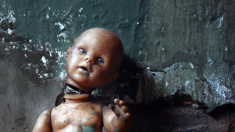 Slow dolly in shot of a creepy doll with a partially severed head