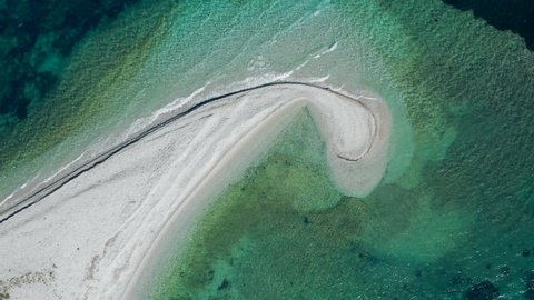 Beautiful drone shot of sandbank like a comma in green gradient sea, Amorgos, Cyclades Island in Greece.