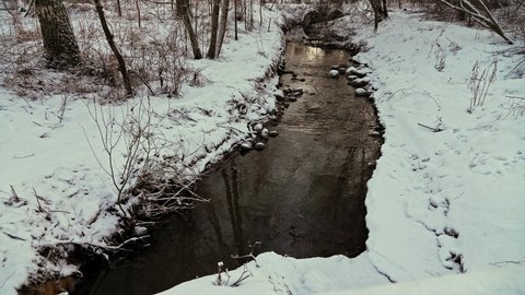 small stream in the snowy forest.and snow covered trees. Winter nature.