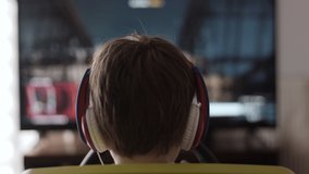 Boy Playing Racing Video Game in Game Console. Child Playing Computer Game in Headphones With Steering Wheel. Gamer With Headset Holding Steering Wheel Playing Video Game. Kid Gambling Addiction.