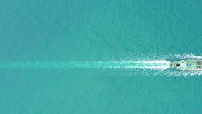 Oil ship full speed in green sea and beautiful splash water in back, transportation import export of waste energy concept, aerial top view footage from drone 4k video 