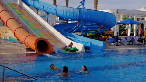 Egypt , Sharm el-Sheikh, Circa 2021. Tourists relax at the sea. Children and adults go from the water slide to the pool. A hotel on the seashore.