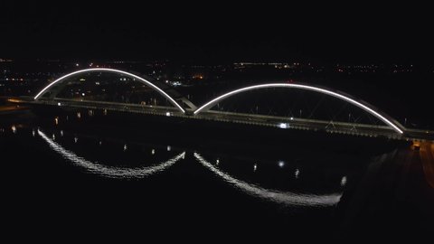 Aerial drone view of new Zezelj bridge in Novi Sad at night, Serbia connecting two sides of Danube river for railroad and transportation architecture concept