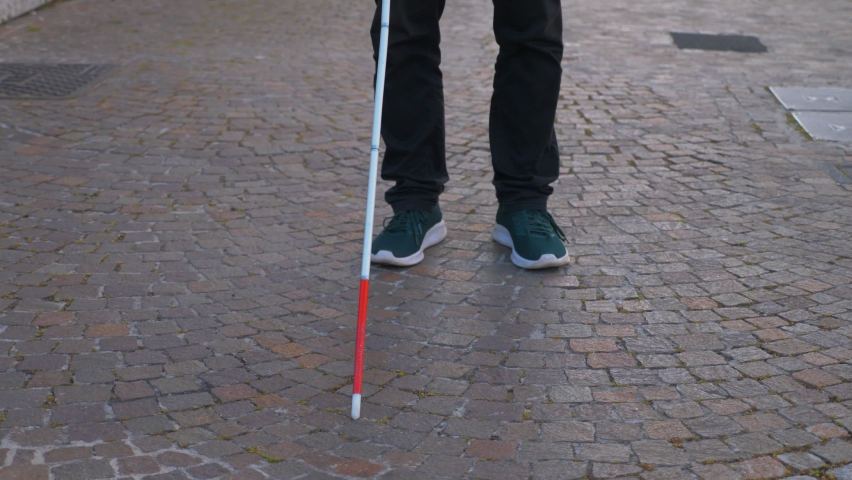 obstacles, impediments - young disabled man unable to move forward with stick stuck on the sidewalk