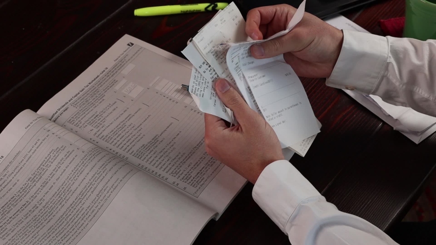 Receipts hold the key to refunds. Sorting out the tax deductions. Royalty-Free Stock Footage #1086056003
