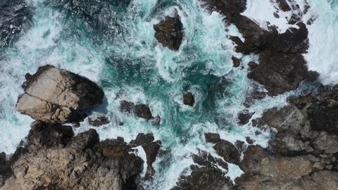 Breaking Waves Into Rocky Outcrops At The Summer Beach Paradise. Aerial Topdown