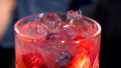 Стоковое видео: Gin mixing by female bartender in slow motion strawberries berries mixology