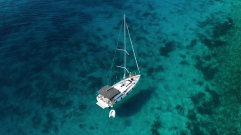 Sailboat With Dinghy Floating In The Pristine Blue Water Of Adriatic Sea Near Paklinski Islands In Hvar, Croatia. - aerial