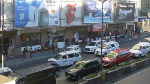 Baguio City, Philippines - December 31, 2021: People and car traffic outside a major supermarket in Baguio City during the last day of 2021 less than 10 hours before New Year's eve. 