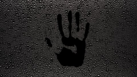 Handprint printed on the wet glass blown off with air stream on black background | shower concept