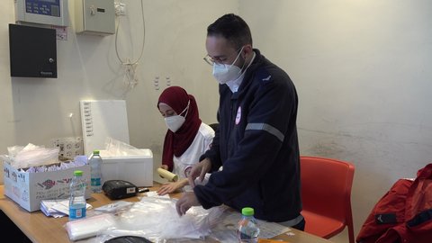 JERUSALEM, ISRAEL – DECEMBER 27 2021: Nurses working for Magen David Adom (Israel's equivalent to the Red Cross) prepare PCR testing kits in Jerusalem. Global pandemic footage.