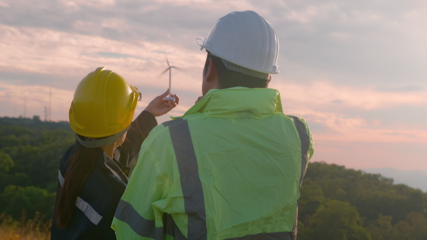 people engineer are wearing a protective helmet on head, using tablet Analytics engineering data.