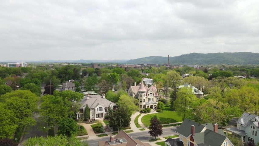 Aerial view of Well established residential neighborhood of historic homes on a beautiful autumn day in Wisconsin. mountains and forest seen in the distance. Cloudy sky. 