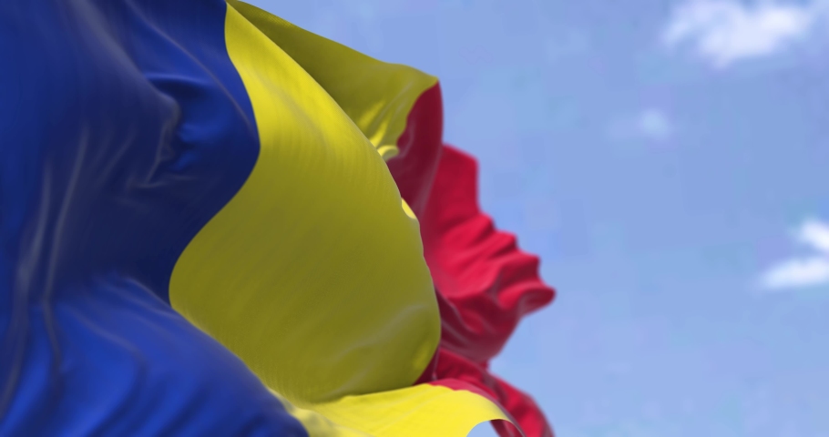 Detail of the national flag of Romania waving in the wind on a clear day. Democracy and politics. Patriotism. Selective focus. Seamless Slow motion