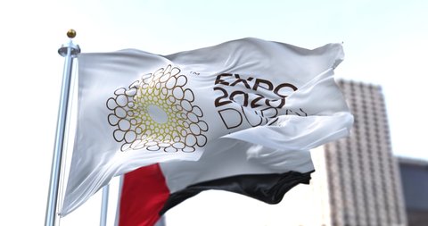 Dubai, UAE, January 2022: the flag of Expo 2020 waving in the wind with the UAE flag blurred in the background. 