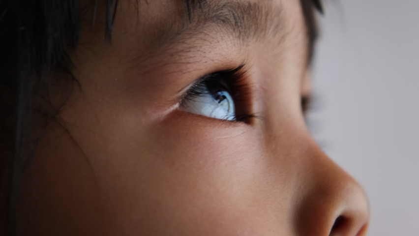 Close up portrait of little Asian child looking up into the sky. Beautiful brown eyes, long eyelashes. | Shutterstock HD Video #1086079166