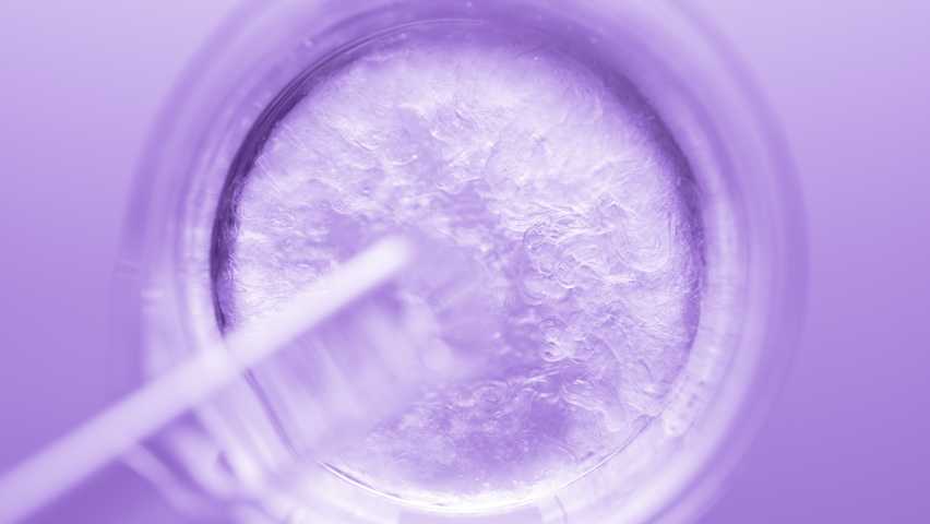 Top view macro shot of glycerin pouring into beaker with water creates ripples on its surface on violet background | Abstract body care cosmetics formulation concept - Powered by Shutterstock - Get 15% off with code: PIKWIZARD15