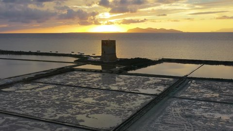 Aerial drone view over a building at a seawater salt brine, sunset in Italy