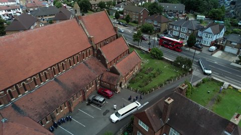 Aerial view wedding ceremony vehicles arrive at charming English village church