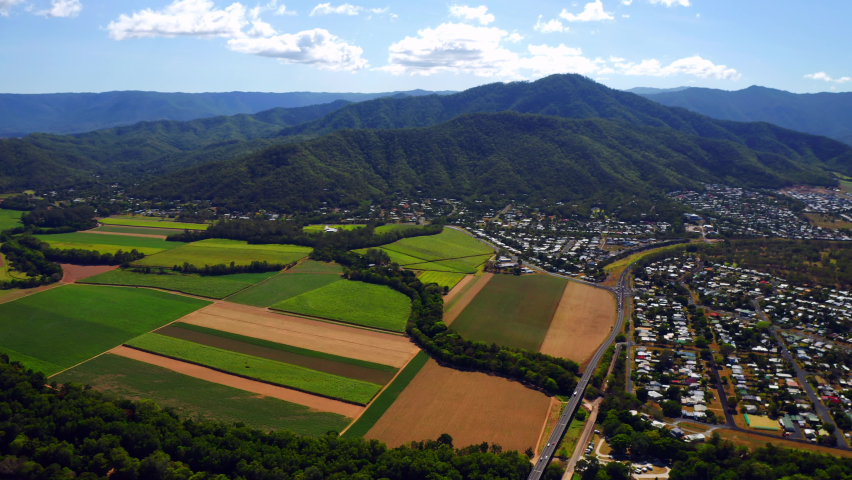 Crops In The Countryside Field Neat Green Mountains And Quiet Town In Cairns, QLD, Australia. - aerial panning