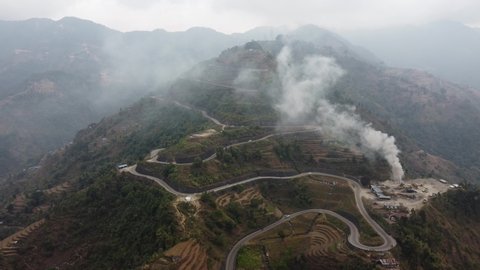 An aerial view of the Bardibas or BP Highway with smoke billowing from a nearby pavement production plant in Nepal.