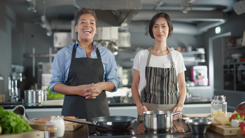 Celebrity TV Cooking Show Kitchen: Asian and Black Female Chefs Talk, Teach How to Cook Food. Online Video Courses, Television Program Presenters. Preparation of Healthy Traditional Fusion Dish Recipe Royalty-Free Stock Footage #1086104420