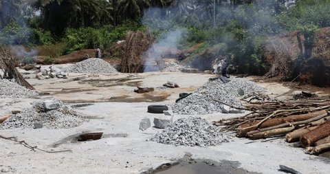 BO, SIERRA LEONE - 17 OCT 2021: Rock quarry Kenema Sierra Leone hard manual labor fire. Sierra Leone, Africa Quarry where rock and stone is mined for commercial use in roads, cement landscape work.