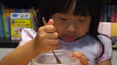 Pretty Asian Toddler Girl  Eating Strawberries