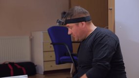 Man with head camera assembling furniture indoors