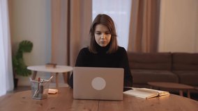A female freelancer works at home uses a laptop communicates on a social network