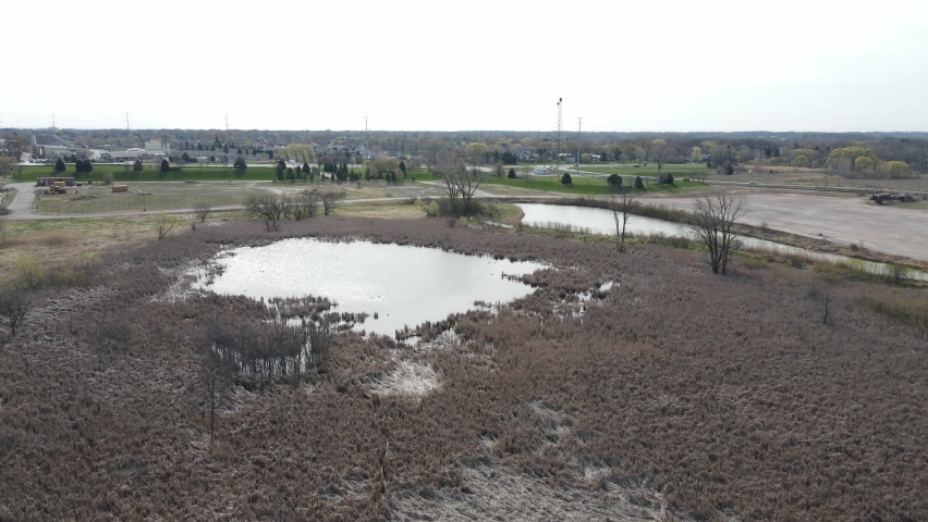 Landscape view of swamp land in rural setting in Wisconsin. Highway and residential community along with business district in distance. 