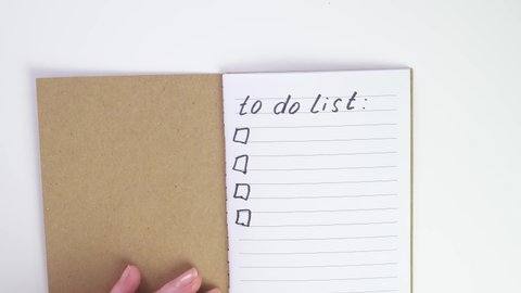 Done To do list. green ticks in notepad. Female caucasian hand notes completed tasks in notebook. Place for text. Text tracking. flat lay to do list write in notebook with a black pen or felt-tip pen.