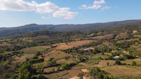 Reverse aerial footage revealing a fantastic landscape and farms then the famous Wat Somdet Phu Ruea, Ming Mueang, Loei in Thailand.