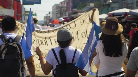 San Salvador , San Salvador , El Salvador - 01 16 2022: Salvadoran walks with national flags during a peaceful protest in the city streets against current president Nayib Bukele