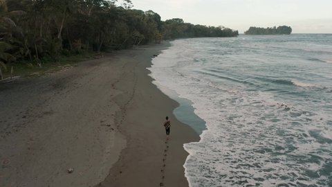 Tourist Walking On The Sand And Leaving Footprints At The Beach In Punta Mona, Costa Rica - Drone Shot