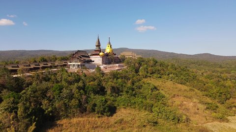 Ascending aerial footage of Wat Somdet in Phu Ruea with a fantastic landscape in the background and the blue sky, Ming Mueang, Loei in Thailand.