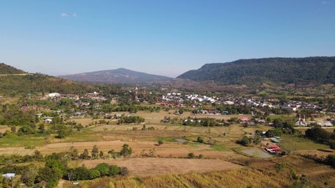 Aerial footage sliding to the left revealing the village and farms of Ming Mueang community near Wat Somdet Phu Ruea in the province of Loei in Thailand.