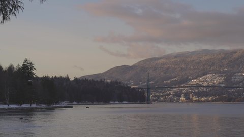 Panoramic View of Modern City, Industrial Site, Lions Gate Bridge, Vancouver Harbour and Mountain Landscape. Winter Sunset. Taken from Stanley Park, Downtown Vancouver, British Columbia, Canada.