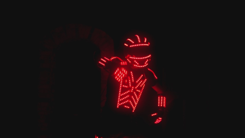 Man dressed in led illuminated costume with colorful lights dancing and moving inside dark interior or club . Dancer guy wearing clothing with neon lights on his body and dances . Shot on ARRI camera | Shutterstock HD Video #1086131468