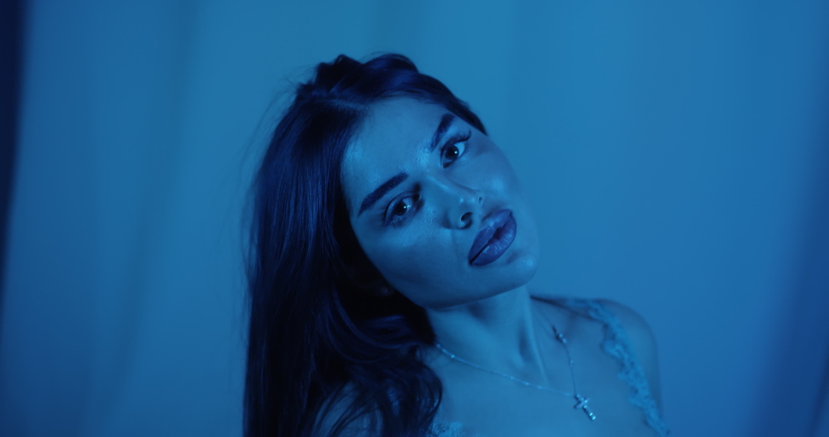 A beautiful young girl in evening blue poses for the camera. Attractive brunette model