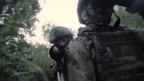 Soldier with a sniper rifle on a military operation, with a partner with a sniper laser rangefinder. Special forces soldiers working as a team.
