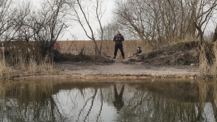 Video effect Dolly Zoom. People on the shore of the lake, autumn landscape.