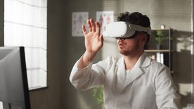 Young male doctor conducting experimental medical procedure wearing virtual reality headset in hospital - Powered by Shutterstock - Get 15% off with code: PIKWIZARD15