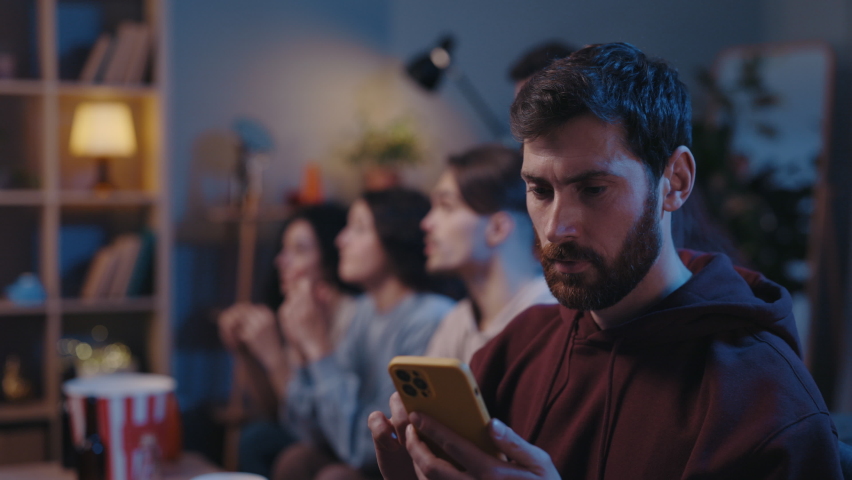 Real human emotions. Cheerful bearded man looking at his device screen and demonstrating happy emotions while looking at results of sports betting during football game. Male fan concept | Shutterstock HD Video #1086139406