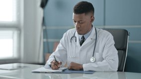 African Doctor Writing on Paper in Office - Powered by Shutterstock - Get 15% off with code: PIKWIZARD15