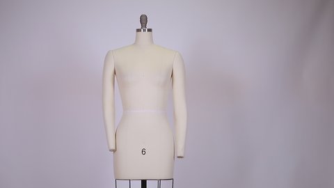 close up of a fabric and metallic vintage dummy dress mannequin standing isolated without clothes on clean and clear background.