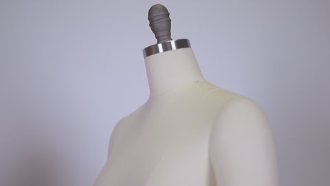 close up of a fabric and metallic vintage dummy dress mannequin standing isolated without clothes on clean and clear background.