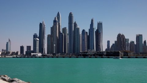 Dubai, UAEmirates - jan 29 2022: 7 times Smooth quick time lapse of the Dubai Skyline with blue sky filmed from the southern tip of Palm Island. View with several more than 400 m high skyscrapers.
